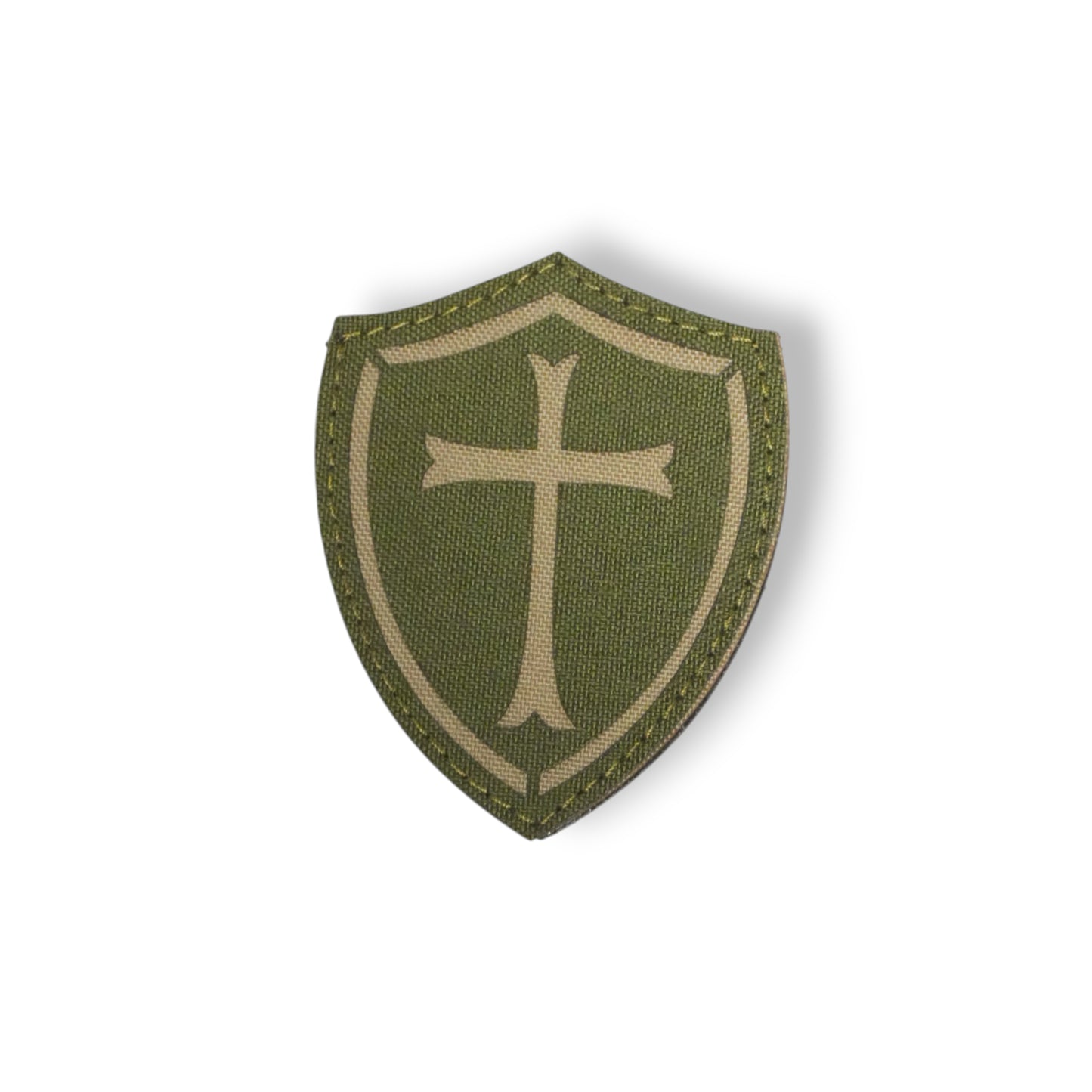 Green shield-shaped patch with a cross on a white background