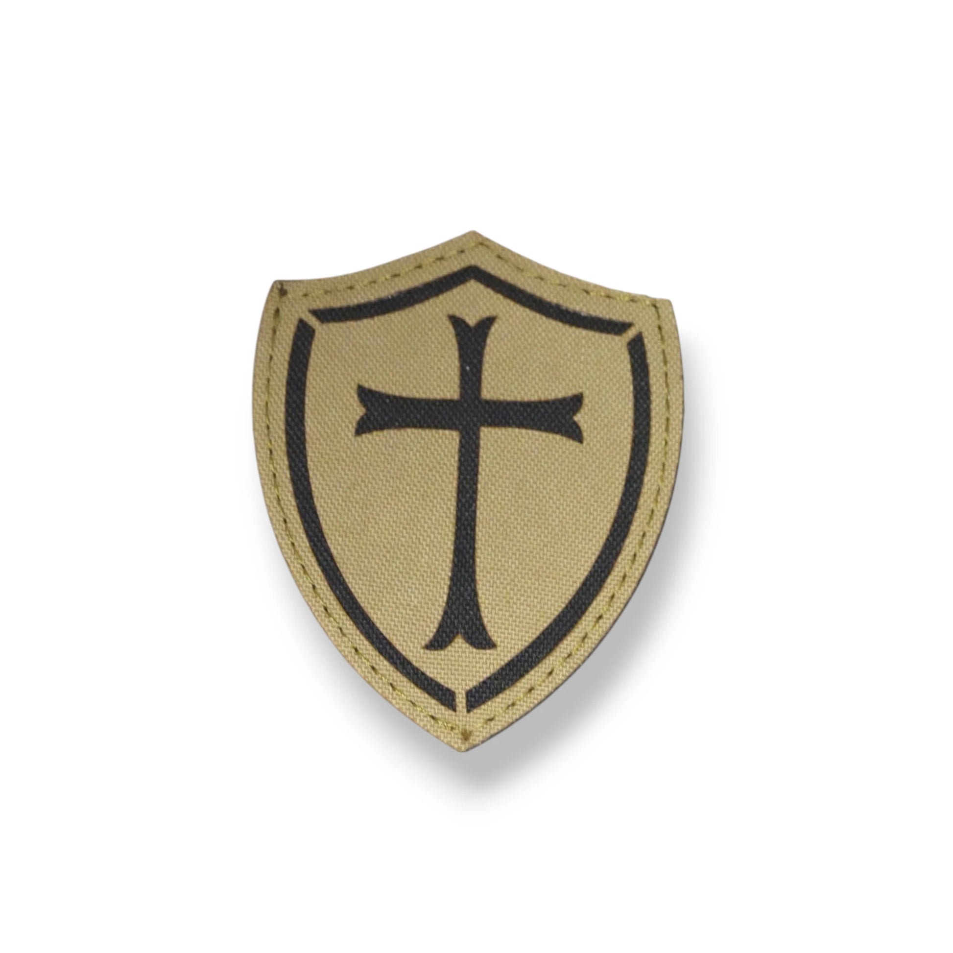 Beige shield patch with black cross on a white background